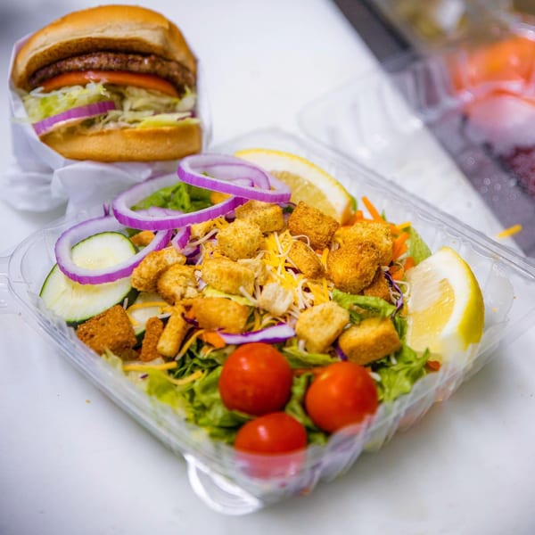 Frosty King burger and a fresh side salad with croutons, tomatoes, and lemon.